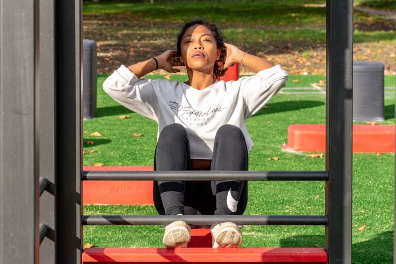 High-strength Markets - woman in white long sleeve shirt and black pants sitting on red metal frame