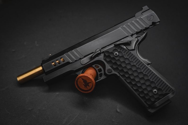 Defense Industry - a close up of a gun on a black surface