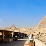 Geopolitical Factors - a woman taking a picture of the pyramids in egypt