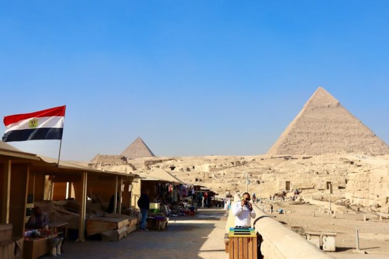 Geopolitical Factors - a woman taking a picture of the pyramids in egypt