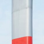 Clean Machinery - a red and white pole against a blue sky