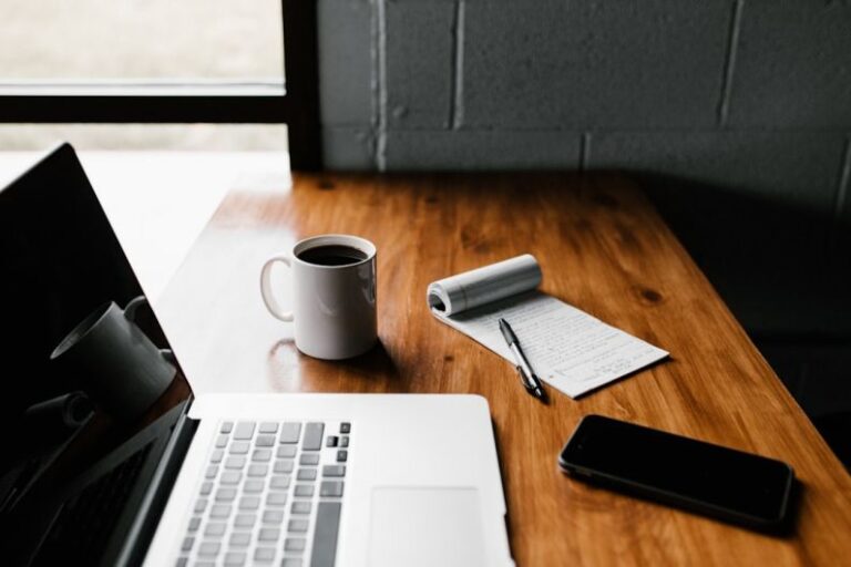 Maintenance Schedule - MacBook Pro, white ceramic mug,and black smartphone on table