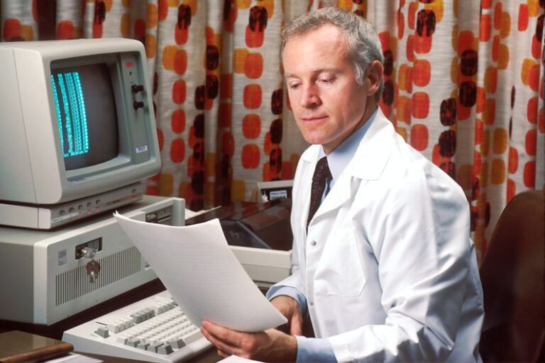 Diagnosing Electrical - man reading papers in front of computer