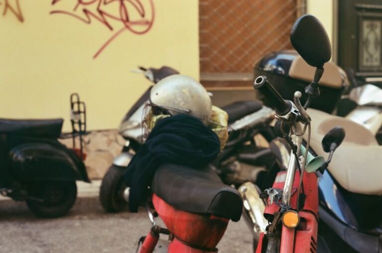 Beveling Machine - a red scooter parked next to a yellow building