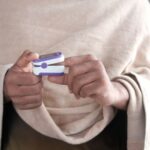 Measurement Device - person in gray sweater holding white and blue smartphone