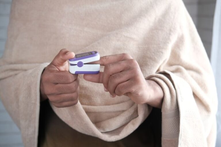 Measurement Device - person in gray sweater holding white and blue smartphone