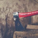 Multi-material - red and black axe on wood slab