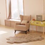 Ergonomic Design - wing chair beside suitcase and window