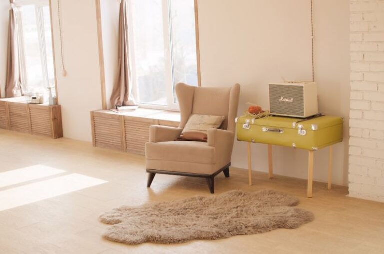 Ergonomic Design - wing chair beside suitcase and window
